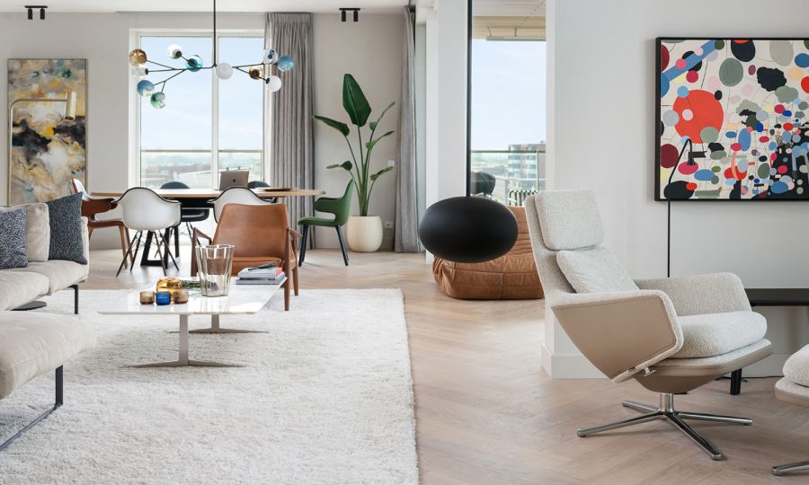 rustige extra grote eiken visgraatvloer in penthouse met eindeloze uitzichten over de duinen van Scheveningen, Vitra Grand Relax loungezetel met Ottoman en de CatchJH1 chair van Jaime Hayon voor &Tradition®  op het kleed staat de Seal lounge chair van Ib Kofod-Larsen| The Woodstore Scheveningen